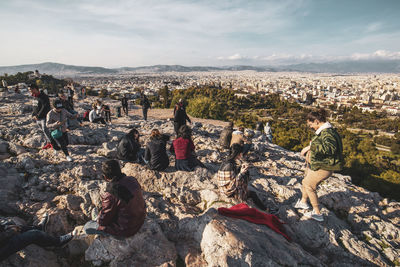 Group of people on rock against sky