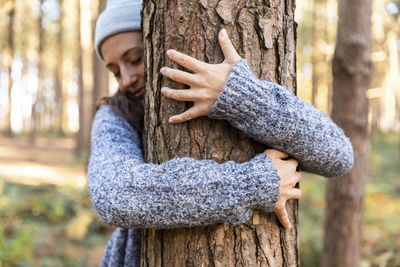 Midsection of man in tree trunk