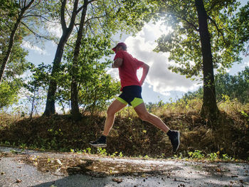 Man running on street amidst trees