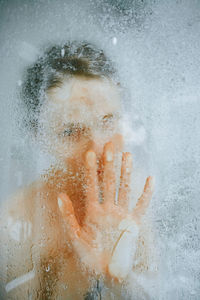 Close-up of woman hand on glass