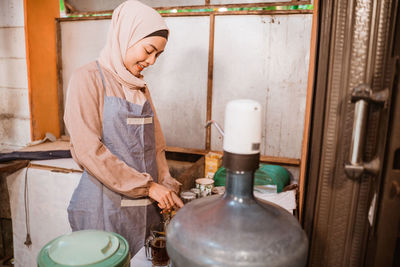 Smiling woman in hijab working at workshop
