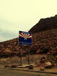 Low angle view of road sign against sky