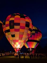 People in hot air balloon against clear sky at night