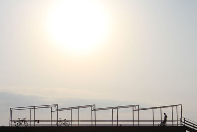 Man on railing against clear sky during sunset