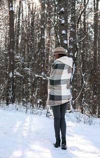 Woman standing on snow covered forest