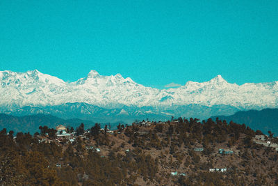 Scenic view of snowcapped mountains against blue sky