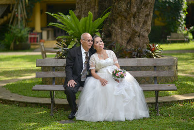 Couple sitting on bench in park