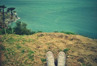 Low section of person on shore by sea