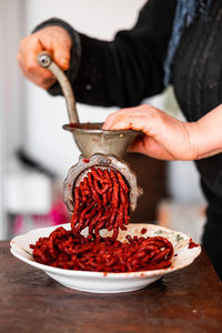 Midsection of man preparing food in bowl on table