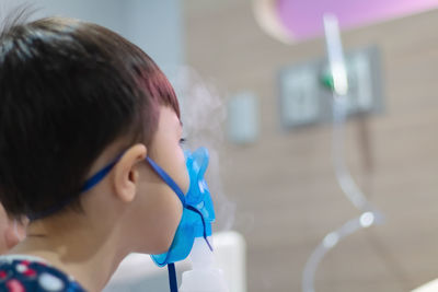 Close-up of boy wearing oxygen mask at hospital