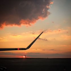 Silhouette airplane against sky during sunset