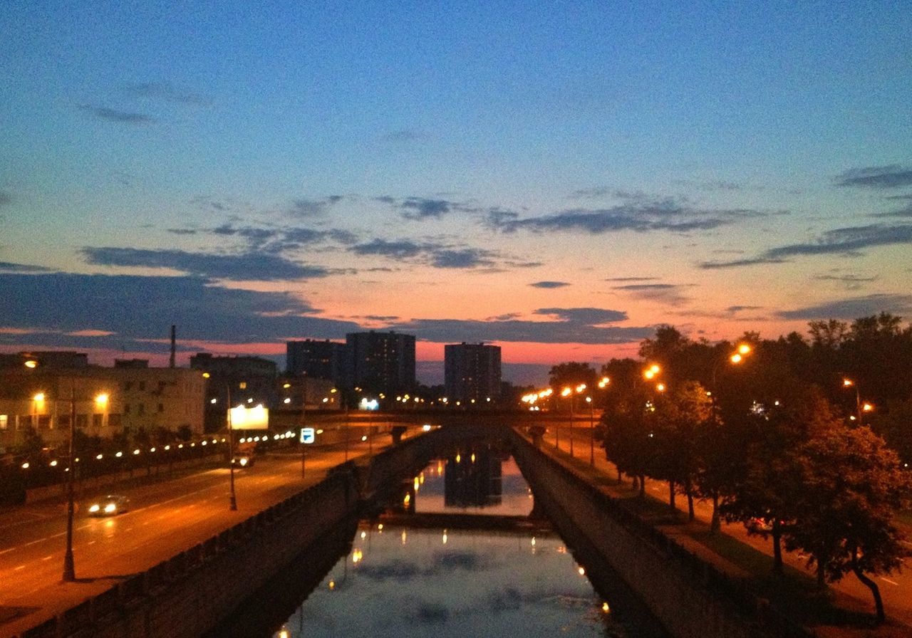 illuminated, sky, building exterior, sunset, architecture, built structure, city, the way forward, night, dusk, street light, transportation, water, high angle view, street, cloud - sky, road, outdoors, diminishing perspective, no people