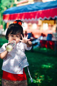 Portrait of cute girl blowing bubbles in park