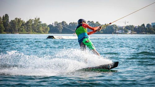 Man surfing in sea against sky