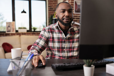 Portrait of young man sitting on table