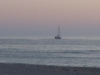 Sailboat sailing on sea against sky