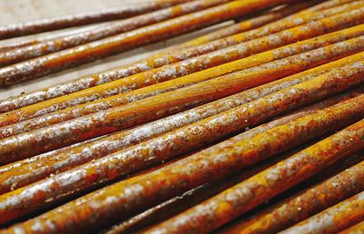 Texture of a group of rusty nails resting on a wooden surface on a construction site.