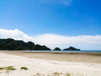 Scenic view of beach against blue sky