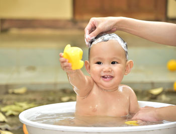 Cute baby boy bathing in tub