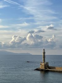 Lighthouse by sea against sky