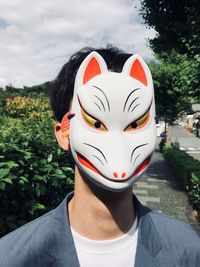 Close-up of man wearing animal mask during sunny day