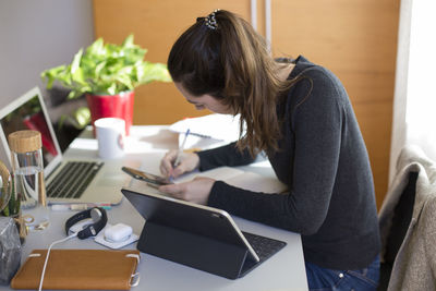 Rear view of woman working on table