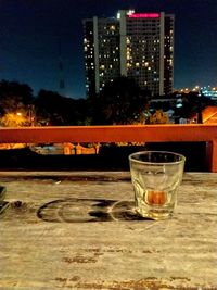 Glass of illuminated building against sky at night