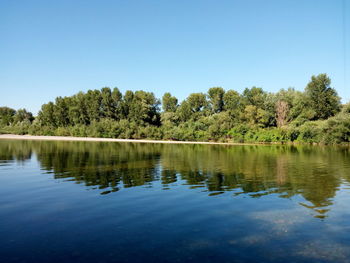 Scenic view of lake against clear blue sky