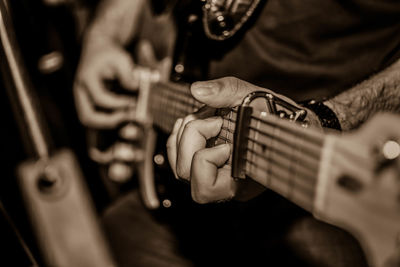 Midsection of musician playing guitar
