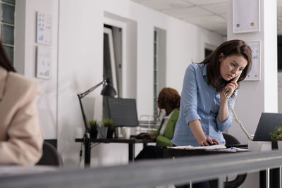 Portrait of woman using mobile phone in office