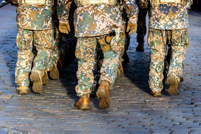 Low section of soldiers walking on footpath