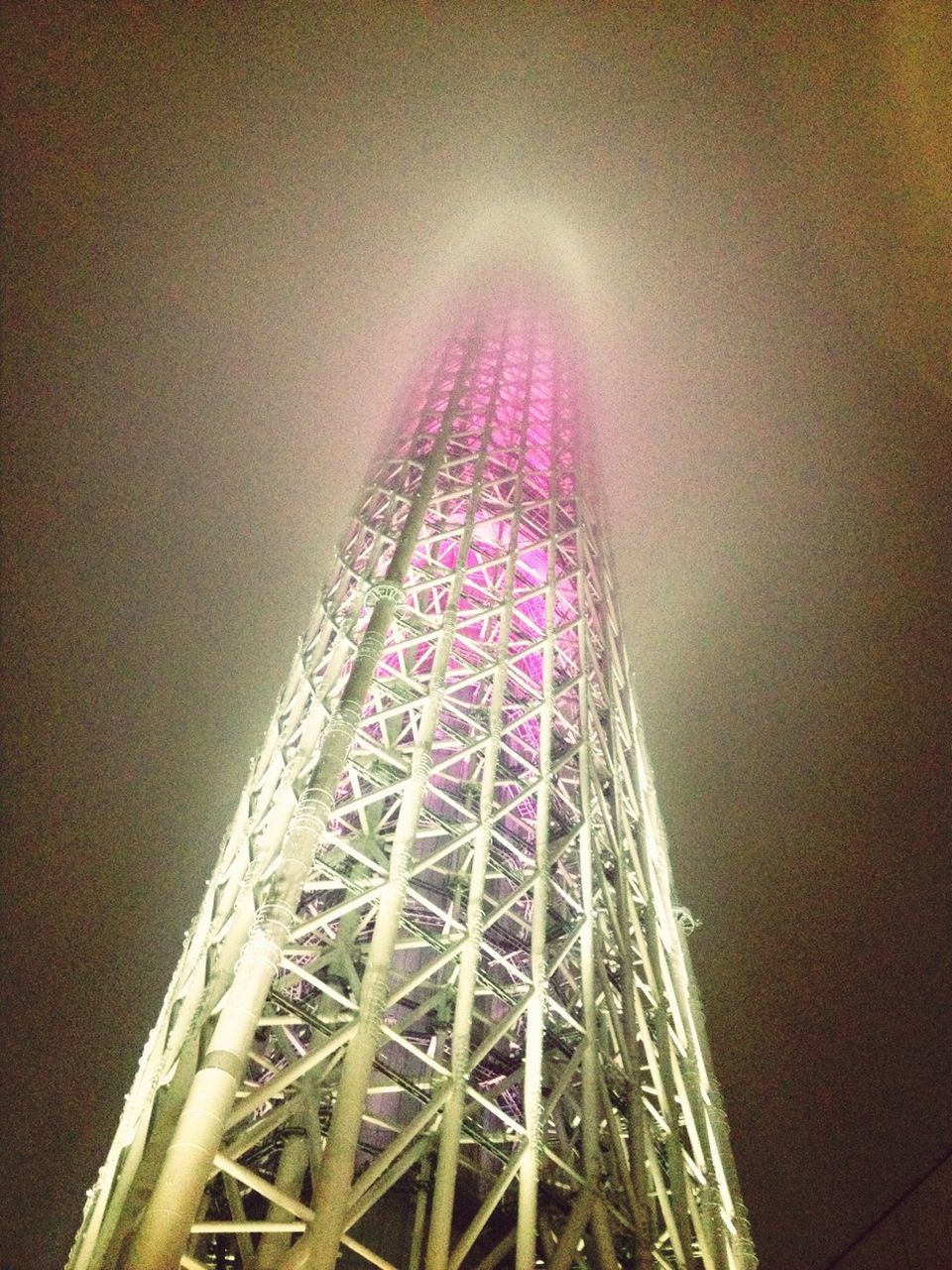 low angle view, built structure, architecture, night, sky, tall - high, illuminated, metal, tower, ferris wheel, building exterior, amusement park, amusement park ride, city, arts culture and entertainment, outdoors, no people, travel destinations, connection, engineering