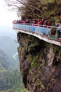 Tourists on bridge by mountain