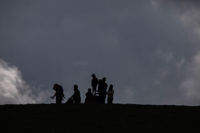 Silhouette people standing against sky