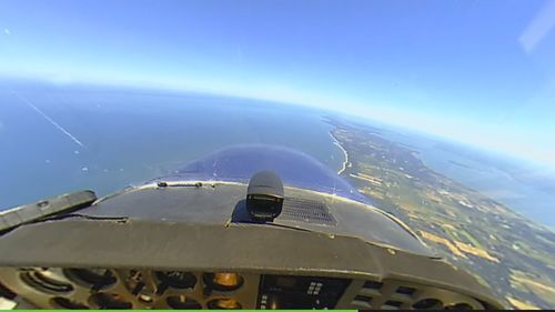 Close-up of airplane wing against blue sky