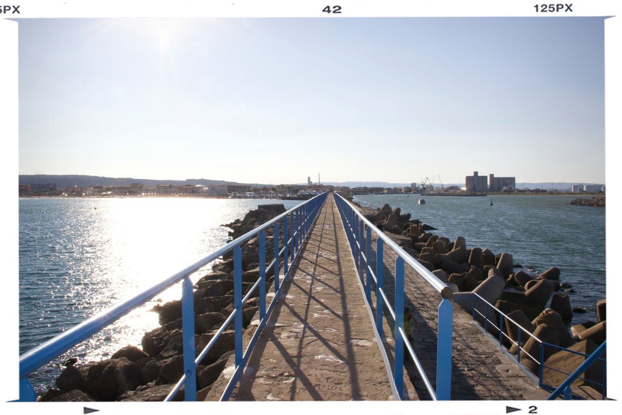 water, clear sky, transfer print, built structure, architecture, sea, copy space, railing, auto post production filter, connection, blue, the way forward, pier, diminishing perspective, bridge - man made structure, sky, river, sunlight, day, long