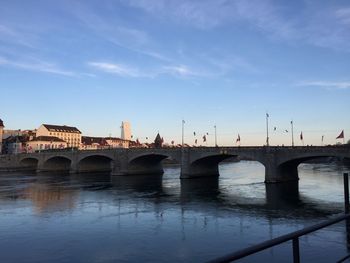 Bridge over river against blue sky in city