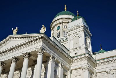 Low angle view of statue of building against clear blue sky