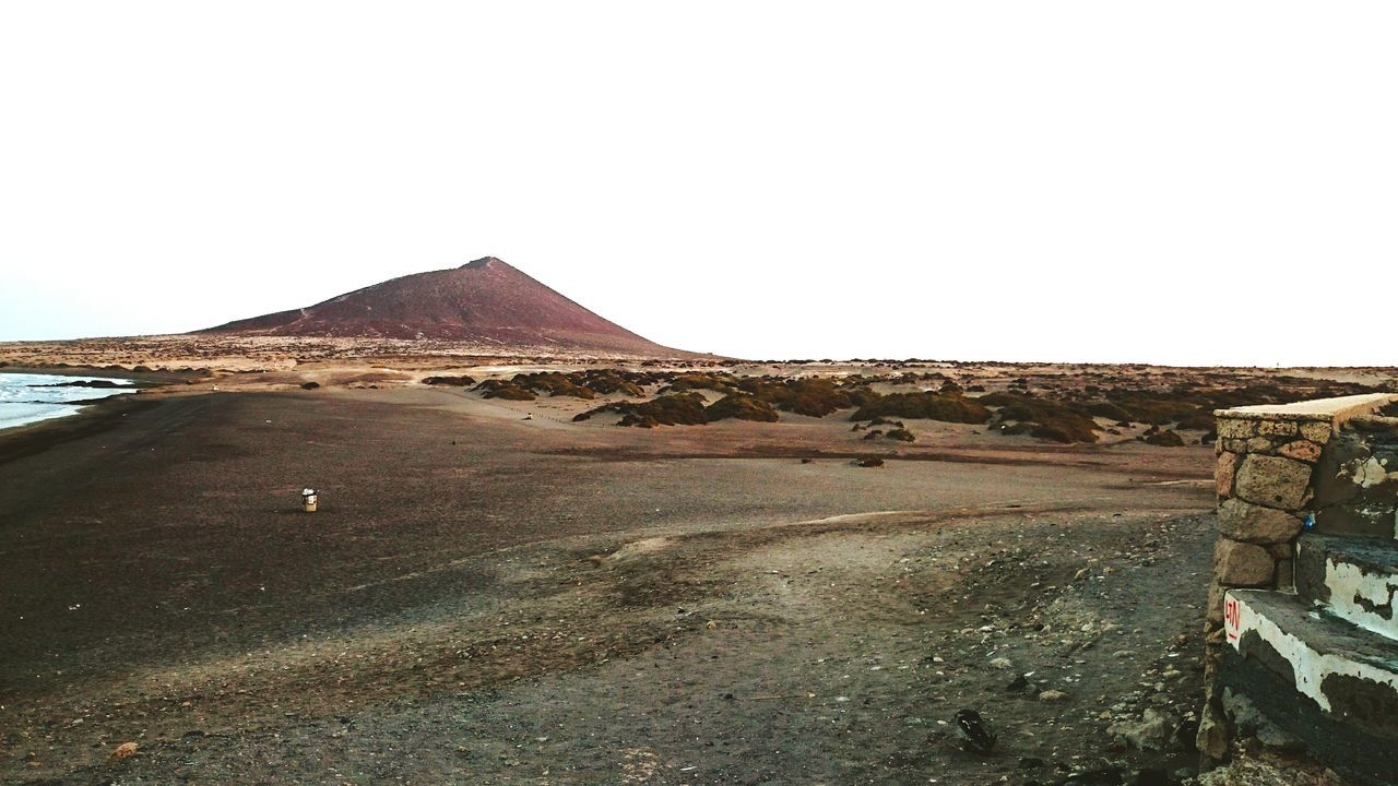 clear sky, copy space, sand, tranquility, mountain, tranquil scene, landscape, scenics, nature, beach, rock - object, arid climate, desert, day, beauty in nature, non-urban scene, outdoors, rock formation, remote, transportation