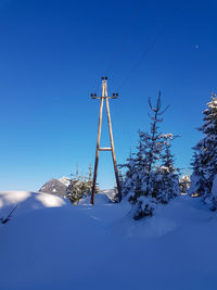 Low angle view of snowcapped mountain against blue sky