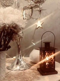 Close-up of illuminated lamp on table at home