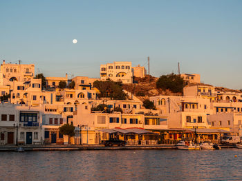 Buildings by river against clear sky