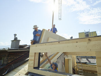 Workers working at construction site on sunny day