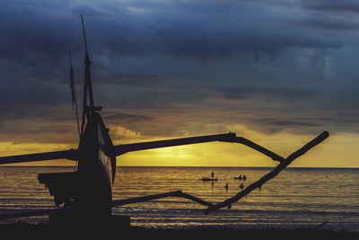 Silhouette pier over sea against sky during sunset