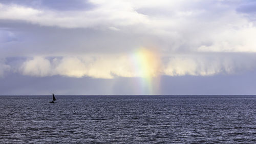 Scenic view of rainbow over sea against sky