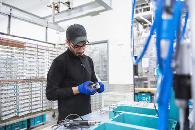 Man working in factory shop floor looking at product