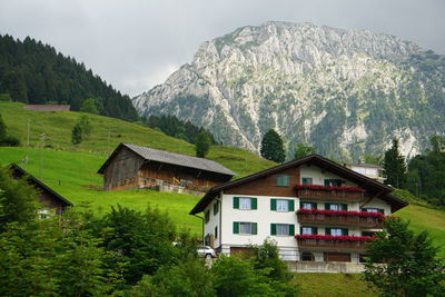 House amidst trees and buildings against sky