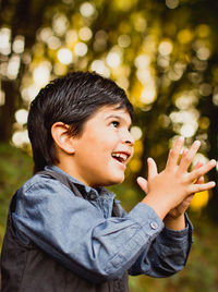 Smiling boy clapping while looking away