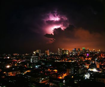 Illuminated cityscape against sky at night