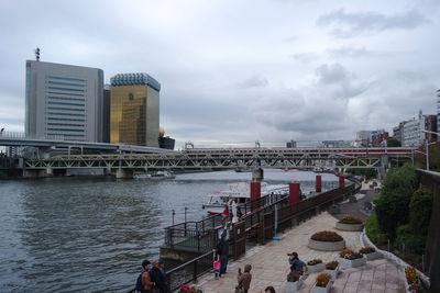 Bridge over river in city against sky